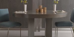 Modern dining table with blue chairs and pendant light.